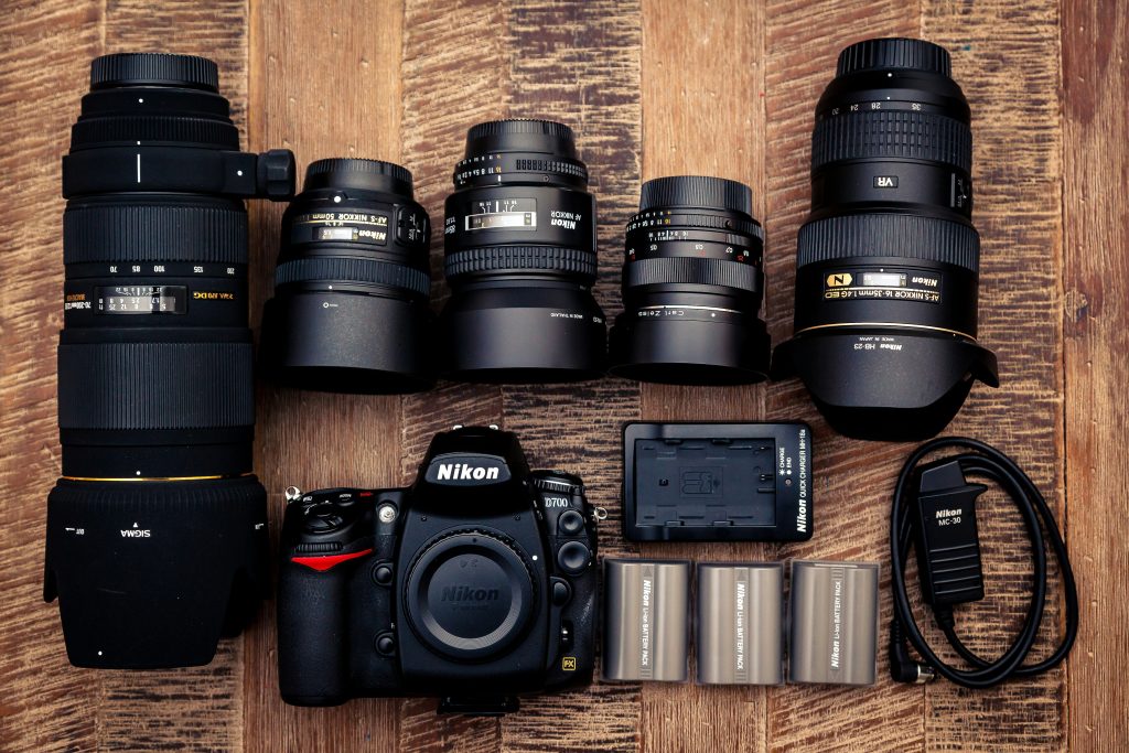 Professional camera equipment with lenses and accessories on wooden surface